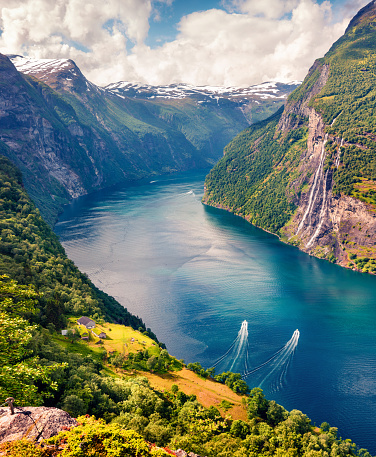 Sunny summer scene of Sunnylvsfjorden fjord, Geiranger village location, western Norway. Aerial view of famous Seven Sisters waterfalls. Beauty of nature concept background.