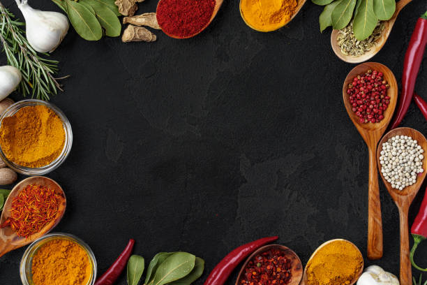 istock Wooden spoons with various spices on black background 1295035186