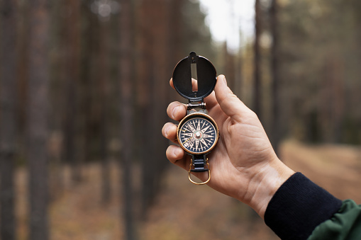Compass in man's hand for searching of right direction