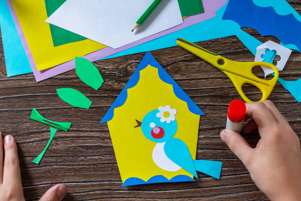 istock Instruction step 9. Spring postcard birdhouse with a bird. Handmade. Project of childrens creativity, handicrafts, crafts for kids. 1295038357
