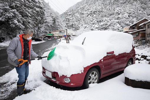 car covered in snow after a blizzard storm snowfall. Transport in winter season under snow