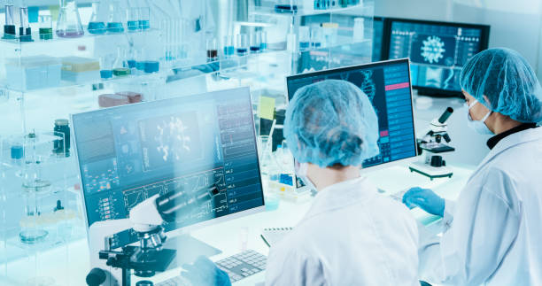 istock Young female microbiologists studying coronavirus. Futuristic lab 1295039428