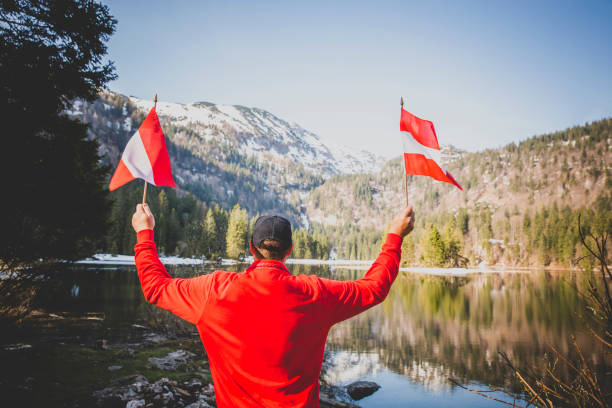istock male hiker is holding two austrian flags 1295039804