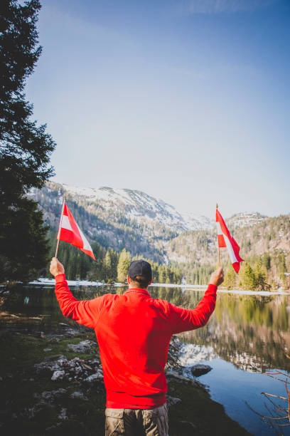 istock male hiker is holding two austrian flags 1295039812