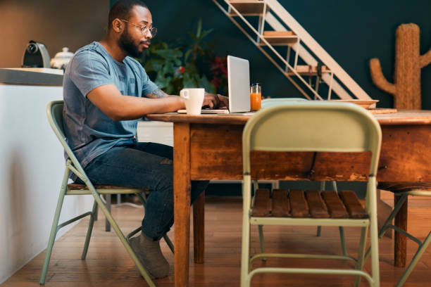 istock Man working from home with a laptop and having breakfast. 1295040812