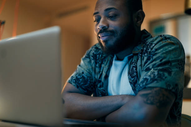 istock Man watching a movie on his computer at home. 1295040914