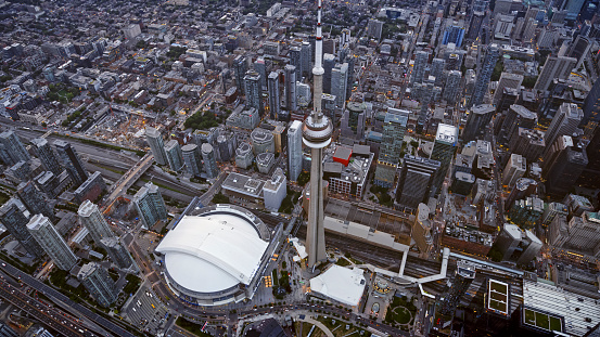 Aerial view of modern cityscape with CN Tower and Rogers Centre stadium at sunset, Toronto, Ontario, Canada.