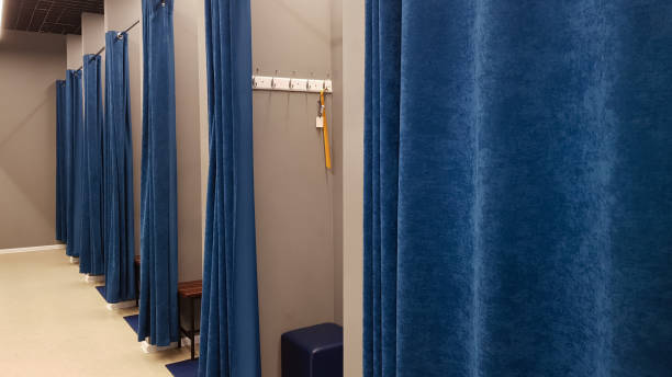 부티크 인테리어, 쇼핑 센터의 피팅 룸. 아무도. 파란색 커튼과 회색 벽과 큰 거울이있는 빈 피팅 룸. 사람이 없는 의류 매장의 탈의실 - 라커룸 뉴스 사진 이미지