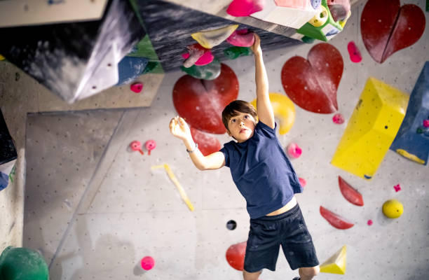 Young boy climbing an indoor climbing wall