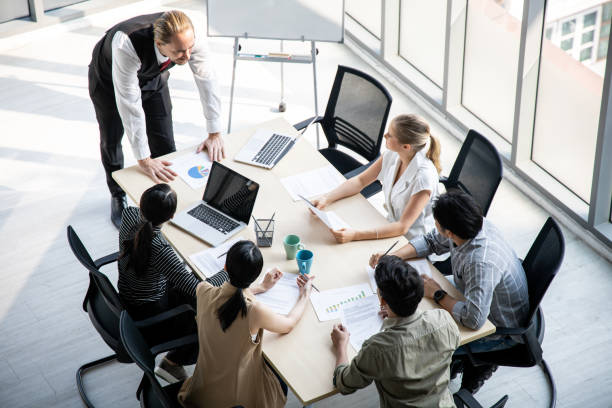 istock Top view of team meeting to analyze assignments. 1295045630