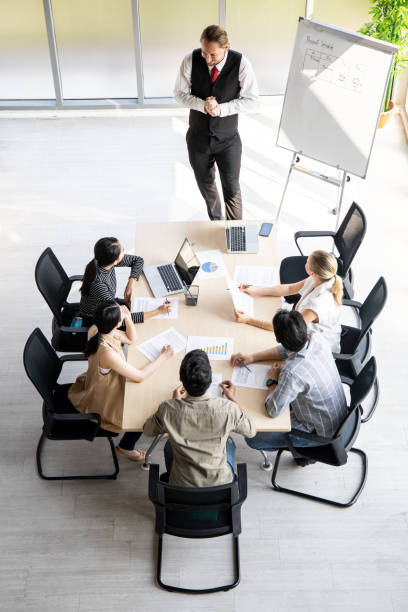 istock Top view of team meeting to analyze assignments. 1295045637