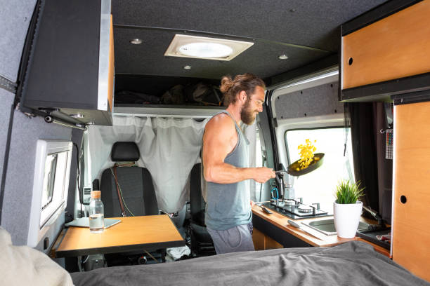 istock Man inside a camper van is cooking on a gas stove 1295048403