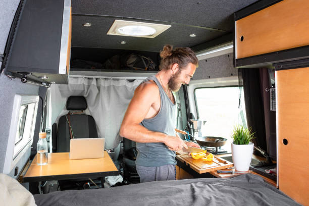 istock Young man preparing food inside his camper van 1295048417