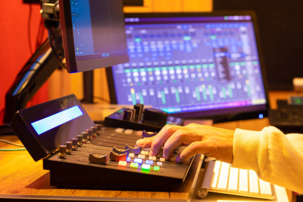 istock male technician, sound engineer hands editing and mixing audio on control surface panel in broadcasting, post production studio. 1295049161