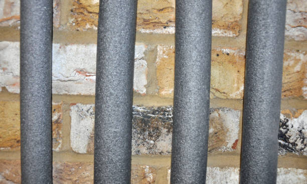 istock Four water pipes in silver grey insulation foam against a brick wall. Studio shot 1295049558