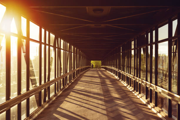 istock pedestrian pathway above highway, golden light shining creating shadows, strong light coming from side 1295049974