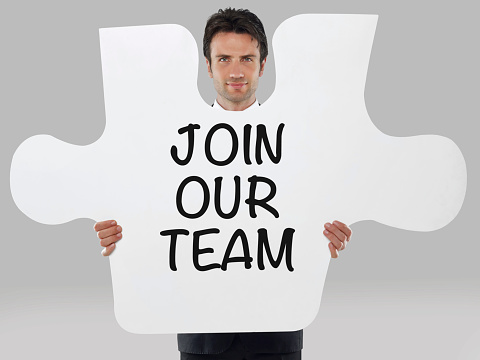 Businessman holding a missing piece of a puzzle with “Join our team” text