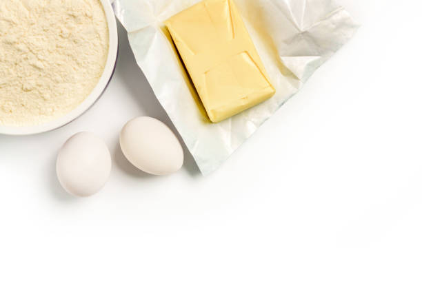 cup with flour, eggs and butter isolated on white background. Ingredients for baking with copy space.