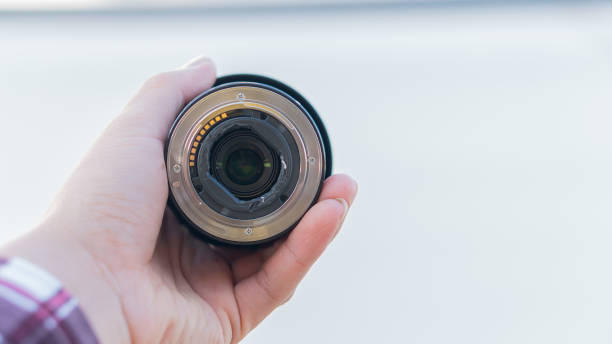 istock A floating lens mount on the ass in a hand holding a white background. 1295057322