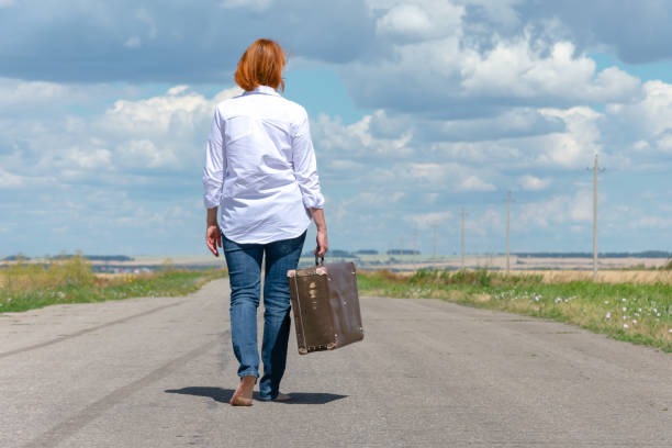 istock A woman hitchhiking alone. 1295057613