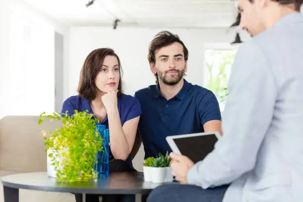 Photo of Couple discussing with financial advisor