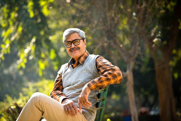 istock Senior man sitting at park bench 1295060777