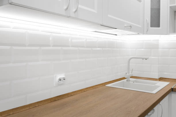 istock White kitchen interior with tiled wall and wooden countertop 1295060886