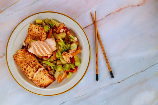 fried pink salmon with asian vegetables on plate with chopsticks. - pink salmon imagens e fotografias de stock