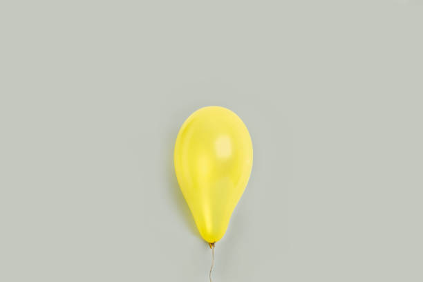 istock A yellow balloon on a gray background 1295061960