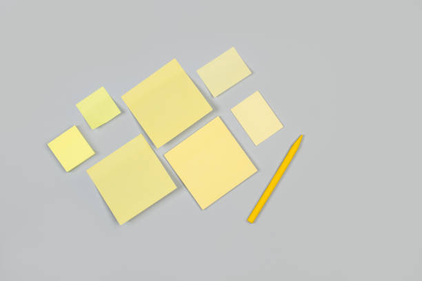 istock Blank sticky notes and a yellow crayon on a gray background 1295062099