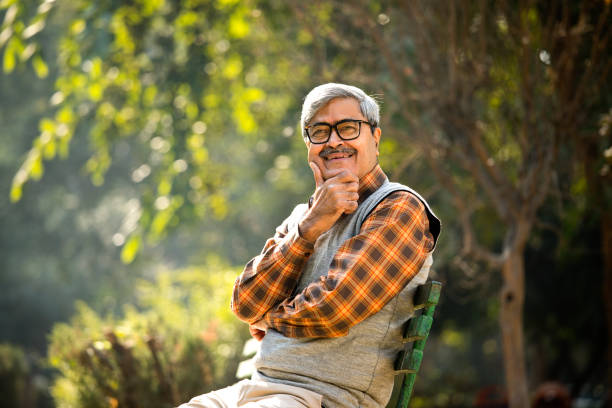 istock Senior man sitting at park bench 1295064294