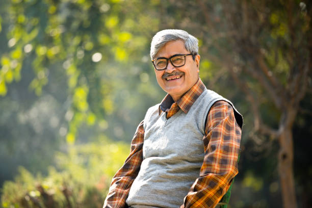istock Senior man sitting at park bench 1295064893