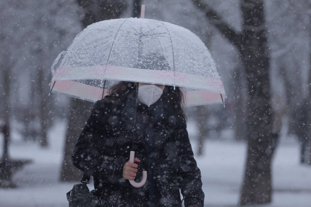 la ragazza cammina veloce nel bel mezzo della bufera di neve, madrid. - sleet foto e immagini stock