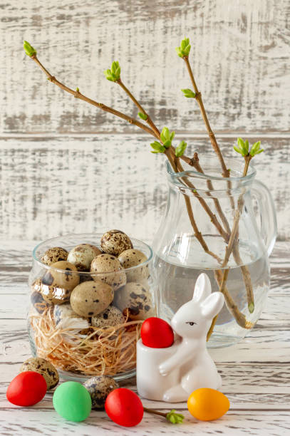 istock Easter composition with eggs, rabbit and spring twigs in glass jar. Happy Easter 1295067583