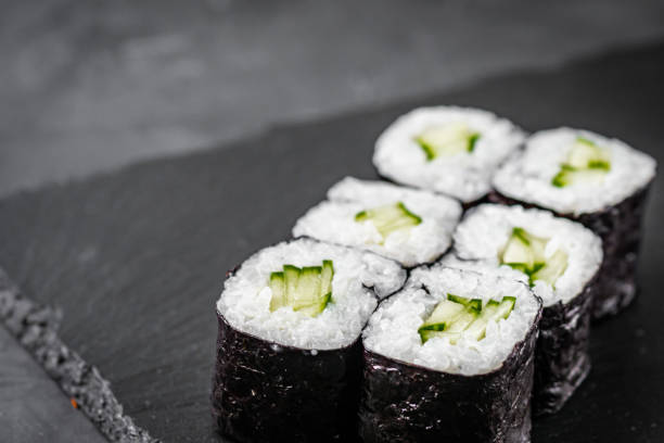 istock appetizing sushi roll maki with cucumber on a black stone plate 1295069309
