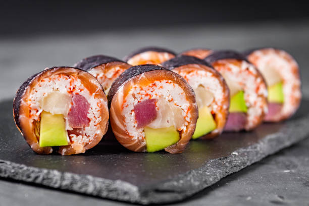 istock appetizing sushi roll with tuna salmon escolar crab and avocado on a black stone plate 1295069574
