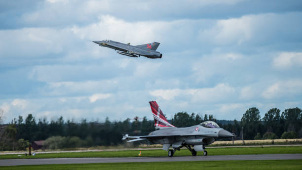 отставной шведский j35 draken взлетает и облагает налогом датский f16 fighting falcon - general dynamics f 16 falcon стоковые фото и изображения