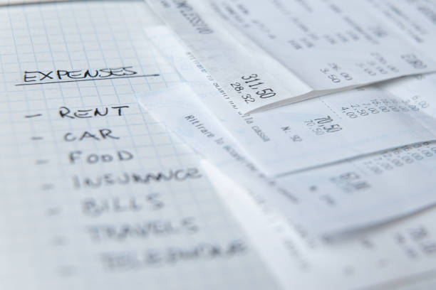 istock List of ordinary expenses, written on checkered notepad and receipts next to it. 1295072114
