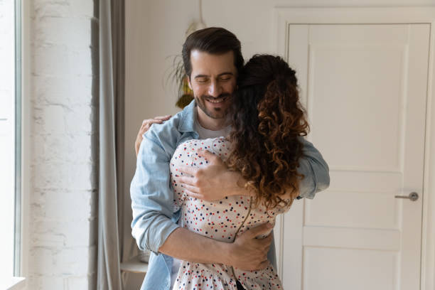 istock Rear view smiling husband hugging wife, enjoying tender moment 1295072627