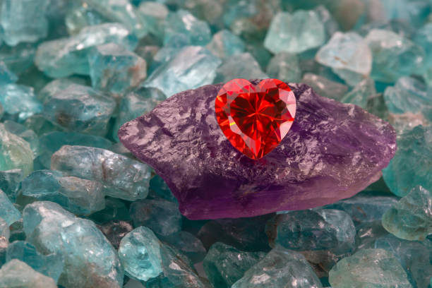 istock Red heart shaped diamond on raw purple amethyst stone 1295073755
