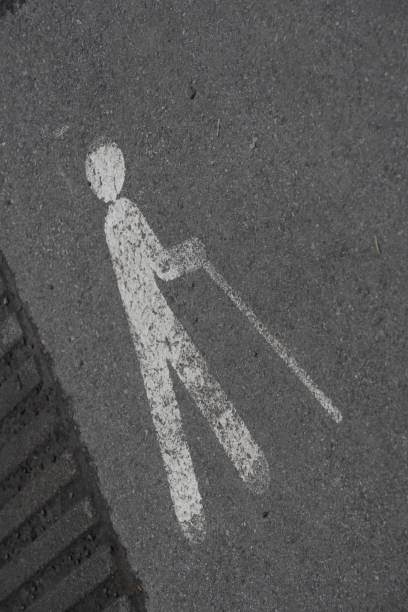 handicapped person with walking aid, white marking on the street