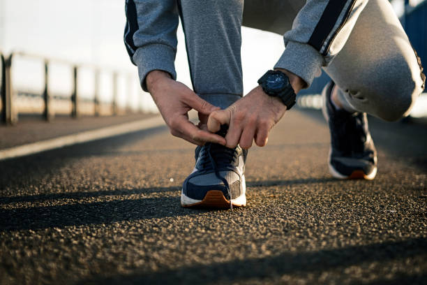 istock Young man tying shoelaces on a sport shoes 1295073947