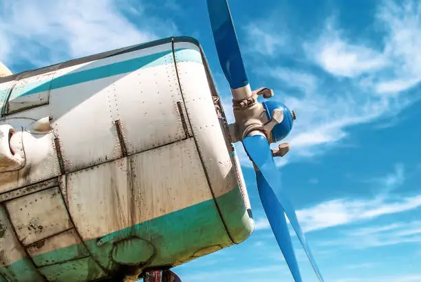 Photo of Old military plane propeller. Vintage fighter plane closeup by blue sky