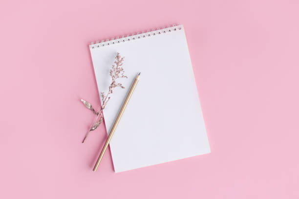 istock Notebook with blank page and pencil on a pink background. 1295081520