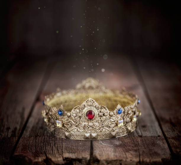 istock Gold Crown on an Old Wood Background 1295081954