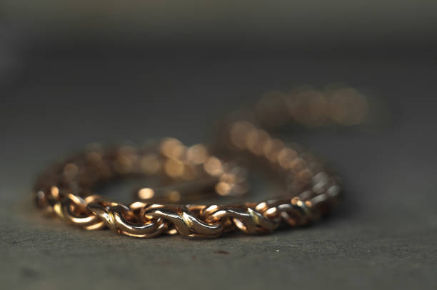 close-up of unfinished bracelet on goldsmith table. jewelry in the manufacturing process. hand weave chain. craft jewelery making with professional tools - cast in stone imagens e fotografias de stock