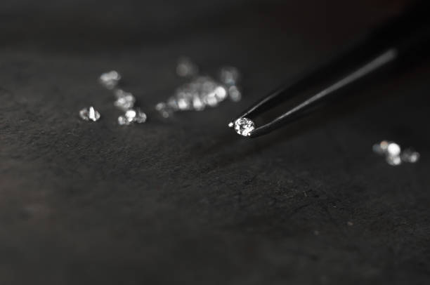 Diamond in tweezers. Craft jewelery, professional tools. Ring repairing. Macro shot stock photo