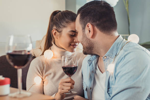 istock Young couple in love drinking wine at home 1295087482