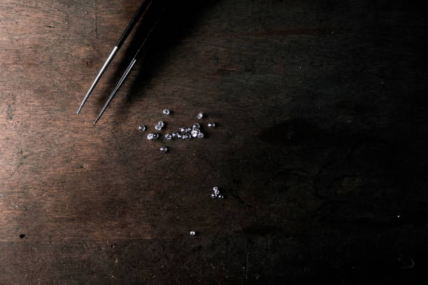 Diamond in tweezers. Craft jewelery, professional tools. Ring repairing. Macro shot stock photo