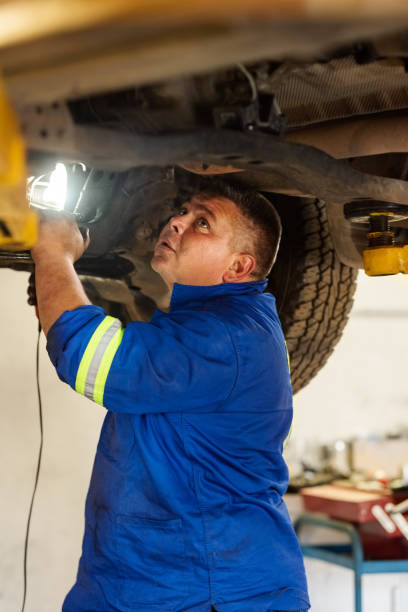 mechaniker untersuchen ein auto - maintenance engineer car lamp protective workwear stock-fotos und bilder